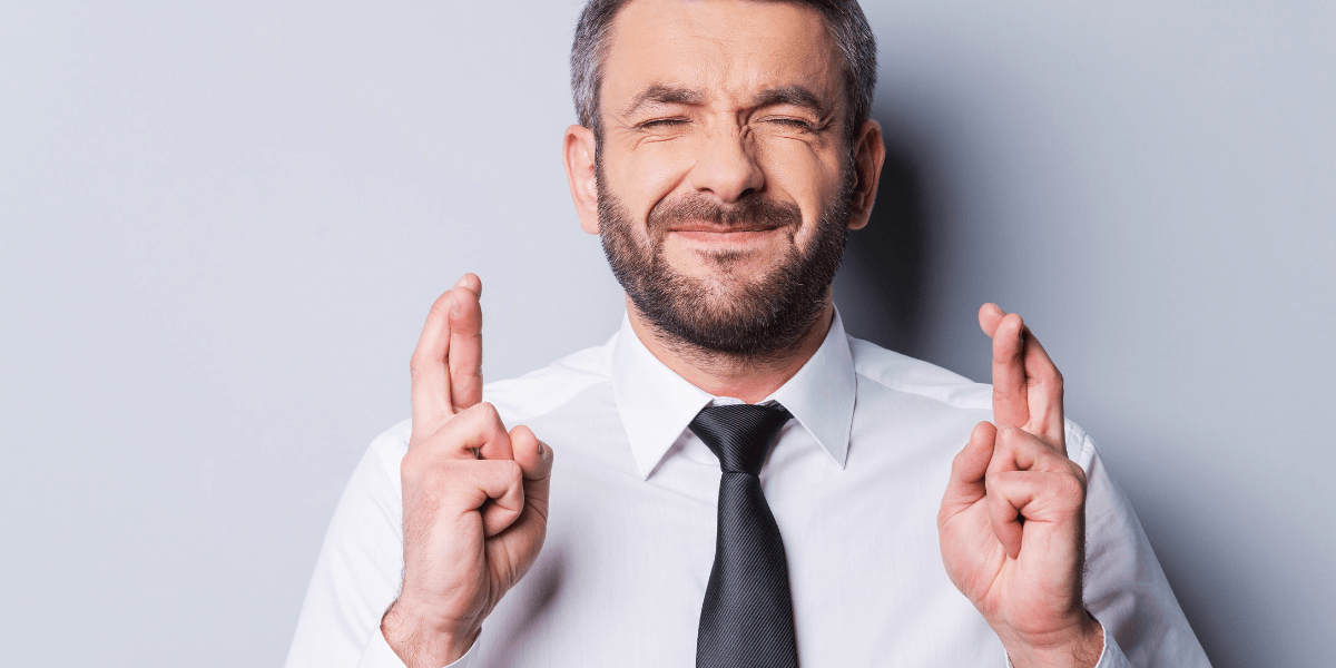 man crossing his fingers for good luck as he is hoping that he qualifies for special enrollment